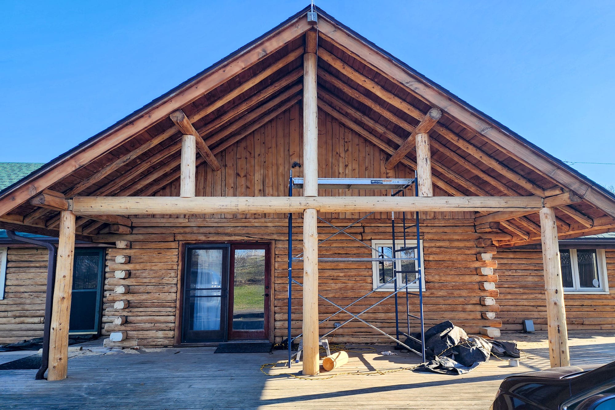 Woman Outside Log Home Sending Images For Estimate to Log Masters Restorations
