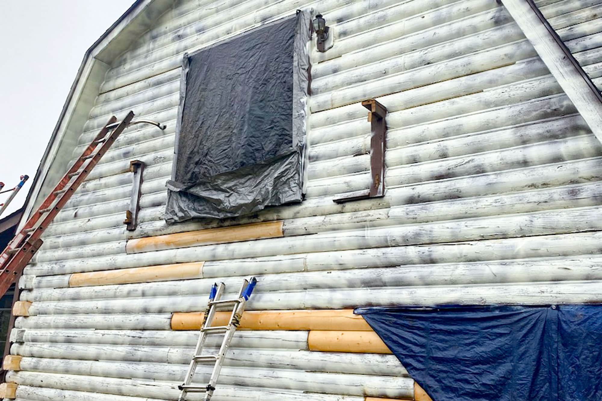 Woman Outside Log Home Sending Images For Estimate to Log Masters Restorations