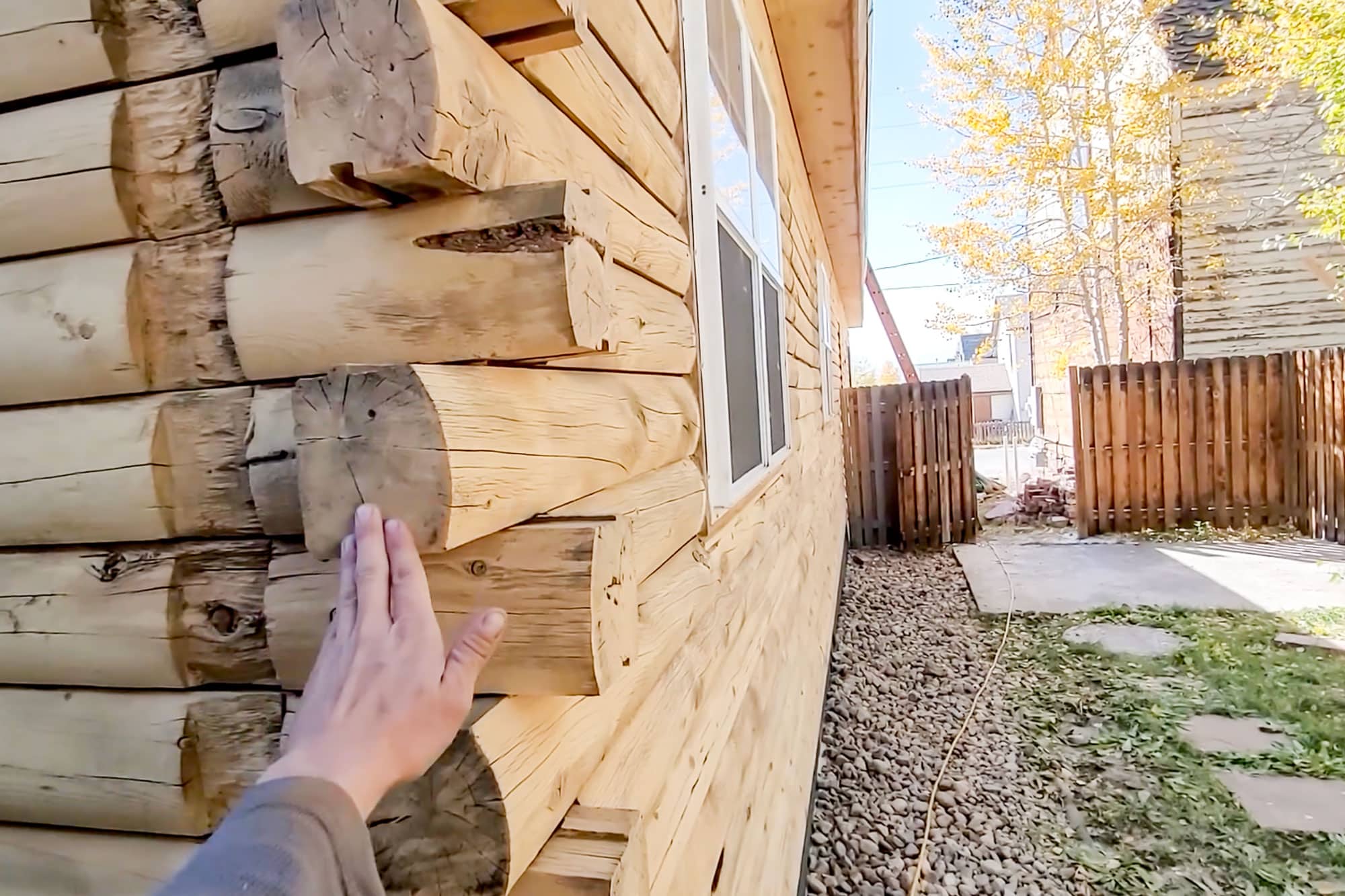 Woman Outside Log Home Sending Images For Estimate to Log Masters Restorations